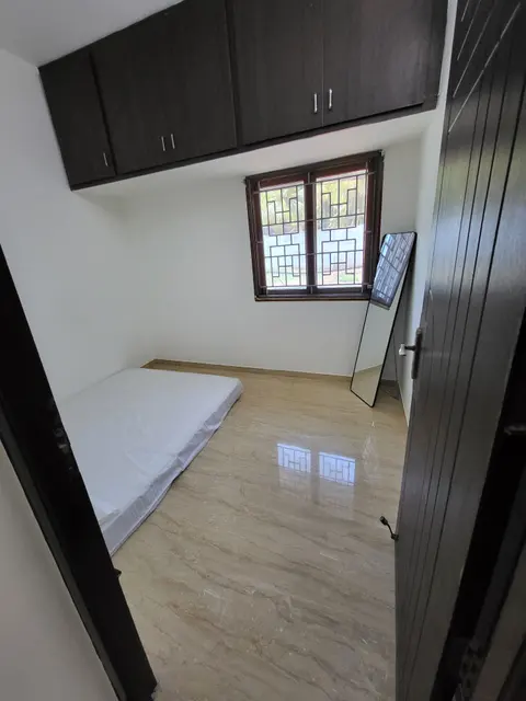 Second bedroom with loft cabinets above the window and a floor mattress