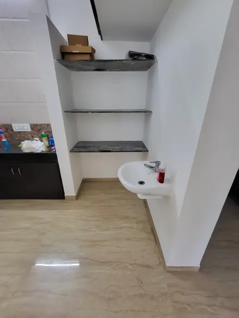 Wall-mounted washbasin with open shelves above, next to the kitchen counter